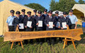 Gruppenbild der geehrten Feuerwehrmänner hinter einem Schild